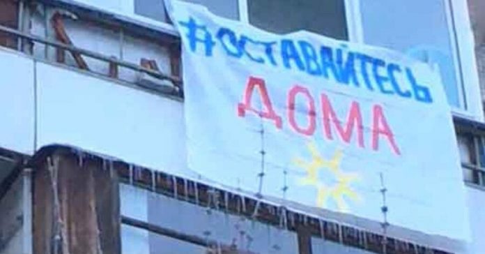 Muscovites hang out on the balconies, and flags calling to stay home
